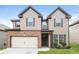 Inviting two-story home featuring a two-car garage, manicured lawn, and stylish architectural details at 4924 Rapahoe Trl, Atlanta, GA 30349