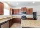 Modern kitchen featuring granite countertops, stainless steel appliances, and wood cabinets at 4924 Rapahoe Trl, Atlanta, GA 30349