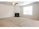 Spacious living room featuring plush carpeting, a ceiling fan, and a cozy fireplace at 4924 Rapahoe Trl, Atlanta, GA 30349
