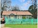 Charming single-story home featuring a cozy front yard with a cute, turquoise picket fence at 6200 Josephine Rd, Atlanta, GA 30340