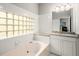 Elegant bathroom featuring a soaking tub with glass block window and granite countertop vanity at 1255 Wildcliff Ne Pkwy, Atlanta, GA 30329