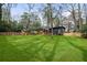 Expansive backyard with a modern home in the background, surrounded by mature trees and a wooden fence at 3637 Eaglerock Dr, Atlanta, GA 30340