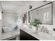 Modern bathroom featuring a freestanding tub, glass shower, and double vanity with a sleek black and white design at 3637 Eaglerock Dr, Atlanta, GA 30340