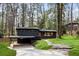 View of contemporary home with dark siding, carport, stone walkway, and natural landscaping at 3637 Eaglerock Dr, Atlanta, GA 30340