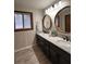 Well-lit bathroom features dual sinks, wood framed mirrors, and new lighting at 1449 Albans Ct, Lithonia, GA 30058