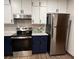 Updated kitchen with stainless steel appliances, granite countertops, stylish blue and white cabinets, and modern backsplash at 1449 Albans Ct, Lithonia, GA 30058