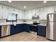 Modern kitchen with white and blue cabinets, stainless steel appliances, granite countertops, and stylish backsplash at 1449 Albans Ct, Lithonia, GA 30058