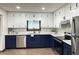 Modern kitchen featuring granite counters, stainless appliances, and white and blue cabinets with sleek hardware at 1449 Albans Ct, Lithonia, GA 30058