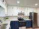 Well-lit kitchen with white upper cabinets and blue lower cabinets, granite countertops, and stainless steel appliances at 1449 Albans Ct, Lithonia, GA 30058