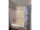 A well-lit tub and shower combo featuring blue-patterned shower curtain at 1449 Albans Ct, Lithonia, GA 30058