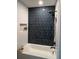 The renovated shower features sleek, vertical tile with black matte fixtures and a built in toiletry niche at 1449 Albans Ct, Lithonia, GA 30058