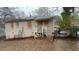 Back of home shows boarded-up windows, covered entrance and chain link fence at 1963 Oak Valley Rd, Decatur, GA 30035