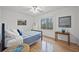 This cozy bedroom features hardwood floors, a blue quilt, and lots of natural light at 2055 Pearwood Path, Roswell, GA 30076