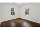 An empty bedroom features hardwood floors, two windows, and white trim at 2595 Old Toney Rd, Ellenwood, GA 30294