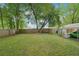 Large backyard enclosed by a wood fence, with a carport and mature tree at 1610 Elm Ne St, Conyers, GA 30012