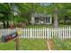 Home's front exterior showcasing well-manicured yard, white picket fence, and colorful landscaping at 1610 Elm Ne St, Conyers, GA 30012