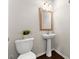Simple powder room with a pedestal sink, toilet, and decorative mirror at 2452 Coosa Vly, Atlanta, GA 30339