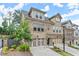 Attractive townhome exterior featuring brick and siding, an attached garage, and well-maintained landscaping at 2452 Coosa Vly, Atlanta, GA 30339