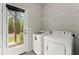 Bright laundry room featuring a washer, dryer, and view to the outside at 2452 Coosa Vly, Atlanta, GA 30339