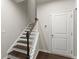 Staircase featuring dark wood steps, white risers and banister, and a door at the bottom of the stairs at 2452 Coosa Vly, Atlanta, GA 30339