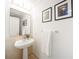 Charming half bathroom featuring a pedestal sink, neutral tones, and decorative wall art at 75 14Th Ne St # 3820, Atlanta, GA 30309