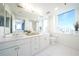 Bathroom featuring dual sinks, white marble counters, and a large window with cityscape views at 75 14Th Ne St # 3820, Atlanta, GA 30309