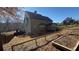 View of the home's backyard featuring a multi-tiered area with garden plots and views of the surrounding wooded area at 3740 Tupelo Trl, Auburn, GA 30011