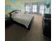 A bedroom with unique yellow and blue wall design, featuring a large bed, multiple windows, and a decorative chandelier at 3740 Tupelo Trl, Auburn, GA 30011