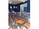 Elegant dining room with a large wooden table, chandelier, and dark blue accent wall at 3740 Tupelo Trl, Auburn, GA 30011