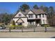 Charming two-story home with brick and stone exterior, well-manicured landscaping, and fenced yard at 3740 Tupelo Trl, Auburn, GA 30011