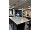 Kitchen featuring a large granite island with bar stool seating, dark cabinetry, and stainless steel appliances at 3740 Tupelo Trl, Auburn, GA 30011