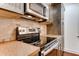 Kitchen featuring stainless steel appliances and granite countertops with natural stone backsplash at 2930 Torreya Se Way, Marietta, GA 30067