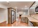 Open kitchen view with stainless steel appliances, warm wood floors, and neutral stone tile backsplash at 2930 Torreya Se Way, Marietta, GA 30067