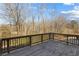 View of back deck with railing offering relaxing outdoor space overlooking backyard with mature trees at 5255 Austrian Pine Ct, Cumming, GA 30040