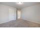 This large bedroom features neutral walls, carpet, a ceiling light, and an adjoining hallway at 5255 Austrian Pine Ct, Cumming, GA 30040
