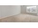 Bright bedroom with neutral walls, plush carpeting, and natural light from a large window at 5255 Austrian Pine Ct, Cumming, GA 30040