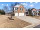 Two-story brick home featuring a two-car garage, well-manicured lawn, and a long driveway at 5255 Austrian Pine Ct, Cumming, GA 30040