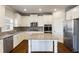 Bright kitchen features white cabinets, stainless appliances, granite countertops and large island at 5255 Austrian Pine Ct, Cumming, GA 30040