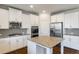 Modern kitchen with stainless appliances, granite countertops, white cabinetry and kitchen island at 5255 Austrian Pine Ct, Cumming, GA 30040