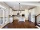 Modern kitchen features stainless steel appliances, white cabinets, and granite countertops, with staircase in view at 5255 Austrian Pine Ct, Cumming, GA 30040