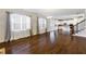 Expansive living room with hardwood floors, large windows, flowing to the kitchen and staircase at 5255 Austrian Pine Ct, Cumming, GA 30040