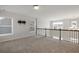 Open loft space perfect for an office or playroom, featuring windows, carpet, and railing at 5255 Austrian Pine Ct, Cumming, GA 30040
