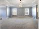Main bedroom featuring tray ceiling, neutral paint, carpet, trim, chandelier, and windows at 5255 Austrian Pine Ct, Cumming, GA 30040
