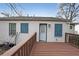 Back patio with wood deck leading to white brick exterior with blue shutters and a white back door at 1322 Lorenzo Sw Dr, Atlanta, GA 30310