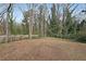 Spacious backyard with mature trees and a wooden fence, perfect for outdoor activities at 1322 Lorenzo Sw Dr, Atlanta, GA 30310