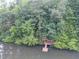 Aerial view of a lake house surrounded by lush greenery and dock at 18 Commerce Row, Cartersville, GA 30121