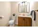 A clean half bathroom with a wood cabinet vanity, bright vanity lighting, and neutral wall color at 2691 Jamerson Rd, Marietta, GA 30066