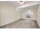 An empty bedroom with carpet, vaulted ceiling, and a large arched window overlooking the wooded backyard at 2691 Jamerson Rd, Marietta, GA 30066