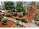 Landscaped front yard featuring mature trees, decorative shrubs, mulch, and stepping stone pathway at 2691 Jamerson Rd, Marietta, GA 30066
