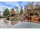 A scenic view of the backyard pond with stone waterfall, patio, deck, and lush landscaping at 2691 Jamerson Rd, Marietta, GA 30066